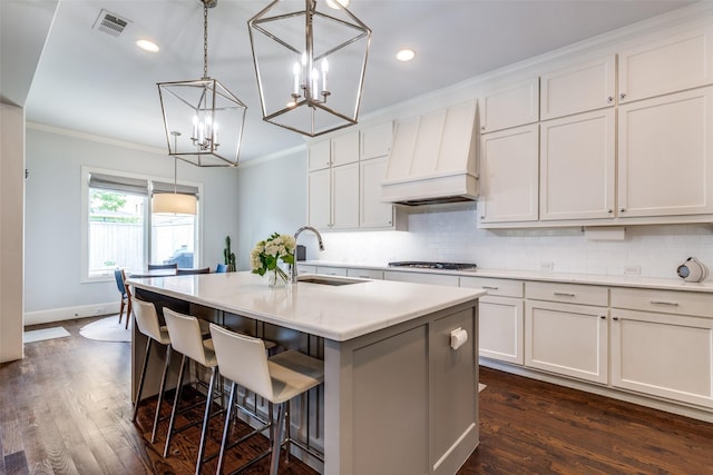 3929 Lively Ln, Dallas, TX 75220 - kitchen with a sink, custom range hood, crown molding, tasteful backsplash, and a kitchen island with sink