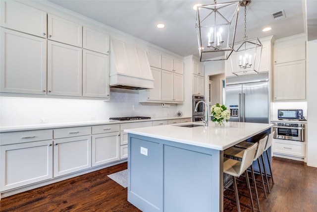 3929 Lively Ln, Dallas, TX 75220 - kitchen with premium range hood, stainless steel appliances, a chandelier, a kitchen bar, and tasteful backsplash