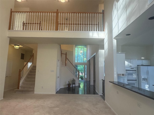 2802 Sunrise Dr, Rowlett, TX 75088 - carpeted entryway featuring a towering ceiling, stairs, and baseboards