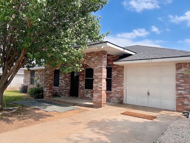 102 Janis St, Alvarado, TX 76009 - view of front of property with concrete driveway, an attached garage, brick siding, and a shingled roof