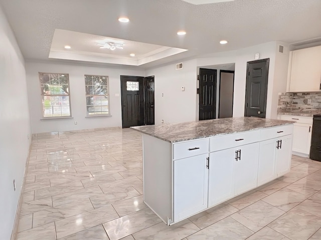 102 Janis St, Alvarado, TX 76009 - kitchen with light marble finish floors, a tray ceiling, a center island, white cabinets, and recessed lighting