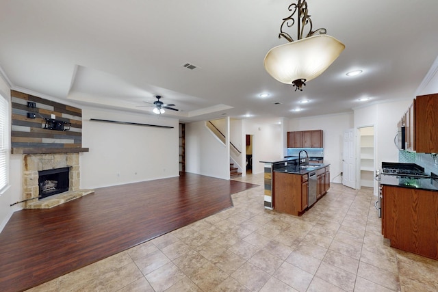 1278 Wysteria Ln, Burleson, TX 76028 - kitchen featuring a sink, dark countertops, appliances with stainless steel finishes, a tray ceiling, and open floor plan
