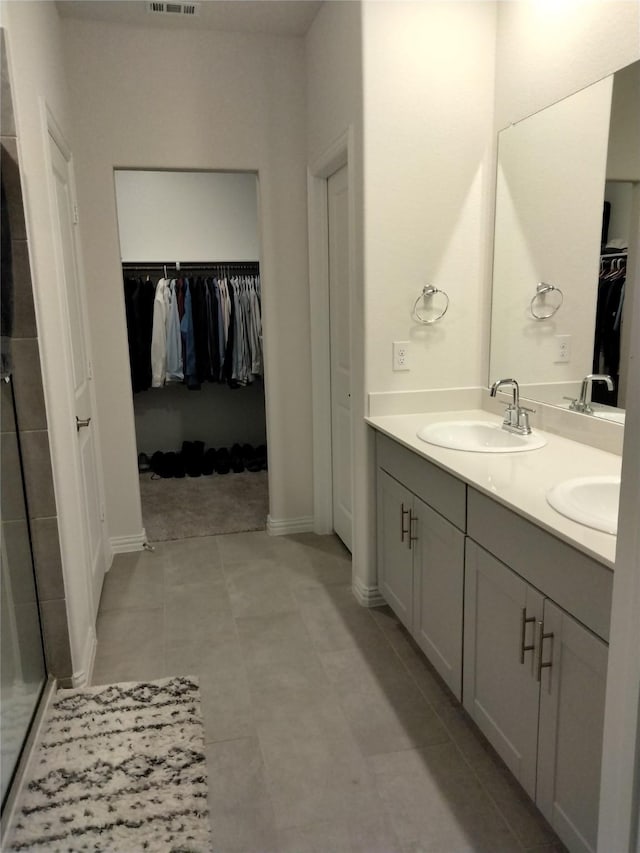 6029 Pathfinder Trl, Fort Worth, TX 76179 - full bathroom with double vanity, a walk in closet, a shower stall, and baseboards
