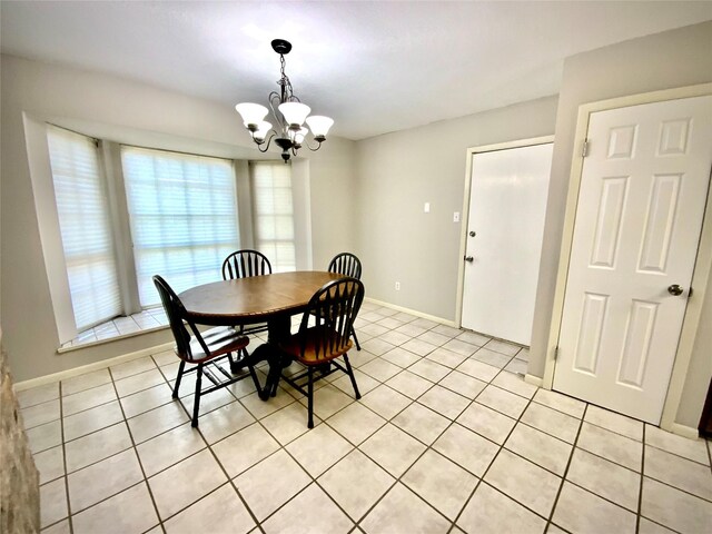 1409 W Trinity, Groesbeck, TX 76642 - dining room with a chandelier, light tile patterned floors, and baseboards