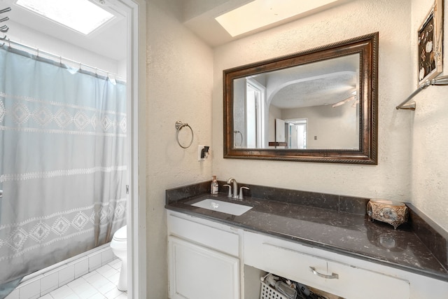 2123 Sunrise Trl, Richardson, TX 75081 - full bathroom with a textured wall, vanity, a skylight, a shower with shower curtain, and tile patterned flooring