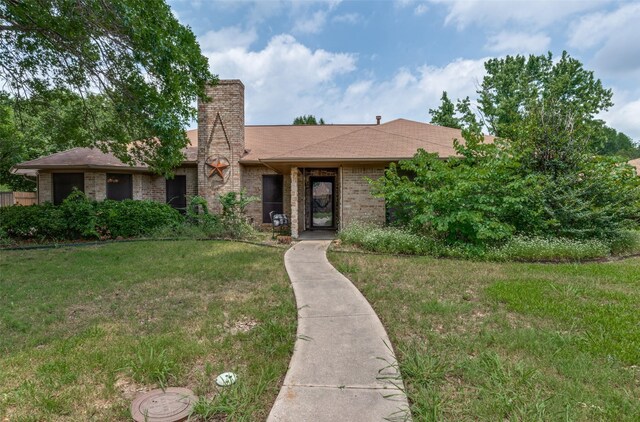 2401 Kingston Trce, Denton, TX 76209 - view of front of home featuring brick siding, a front lawn, a chimney, and a shingled roof
