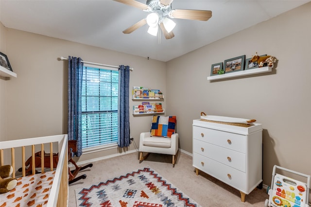 2401 Kingston Trce, Denton, TX 76209 - bedroom with light colored carpet, a crib, baseboards, and a ceiling fan