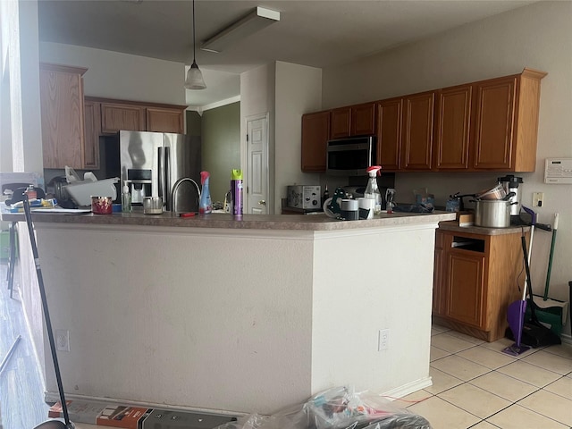 2225 W Appaloosa Dr, Lancaster, TX 75146 - kitchen with stainless steel appliances, light tile patterned floors, brown cabinets, hanging light fixtures, and a sink