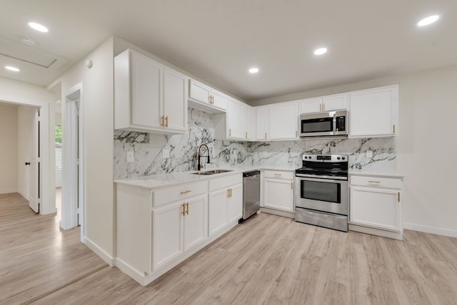 4901 Wilmington Dr, Fort Worth, TX 76107 - kitchen featuring stainless steel appliances, a sink, light wood-type flooring, white cabinetry, and recessed lighting