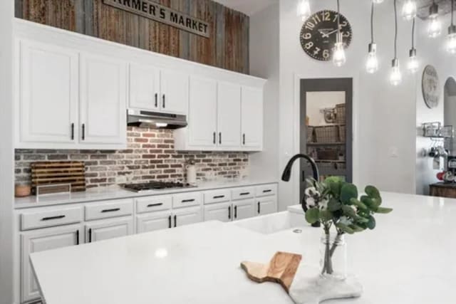 1104 Killian Dr, Mansfield, TX 76063 - kitchen with under cabinet range hood, gas stovetop, light countertops, and white cabinets