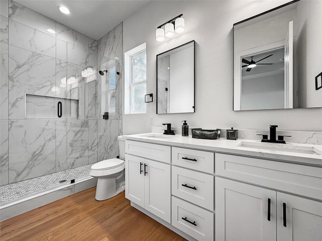 2417 Merlin St, Dallas, TX 75215 - bathroom with a marble finish shower, double vanity, toilet, a ceiling fan, and wood finished floors