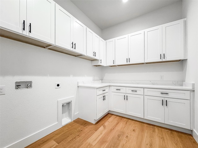 2417 Merlin St, Dallas, TX 75215 - laundry area with light wood finished floors, cabinet space, hookup for a washing machine, and hookup for an electric dryer