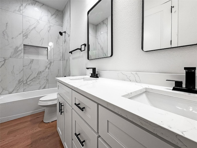 2417 Merlin St, Dallas, TX 75215 - full bathroom with toilet, double vanity, wood finished floors, shower / bath combination, and a textured wall