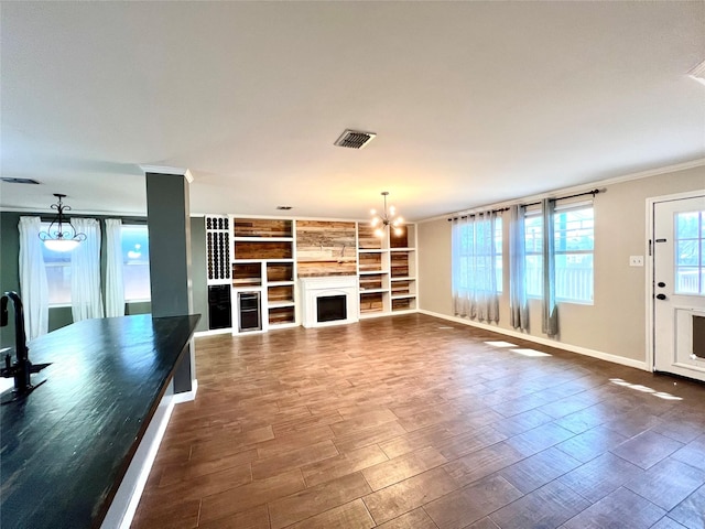 608 Marbury Way, Wylie, TX 75098 - unfurnished living room with crown molding, a chandelier, baseboards, a fireplace, and dark wood-style flooring