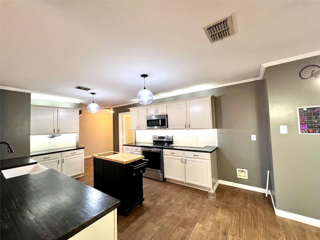 608 Marbury Way, Wylie, TX 75098 - kitchen featuring appliances with stainless steel finishes, a sink, crown molding, decorative backsplash, and dark wood finished floors