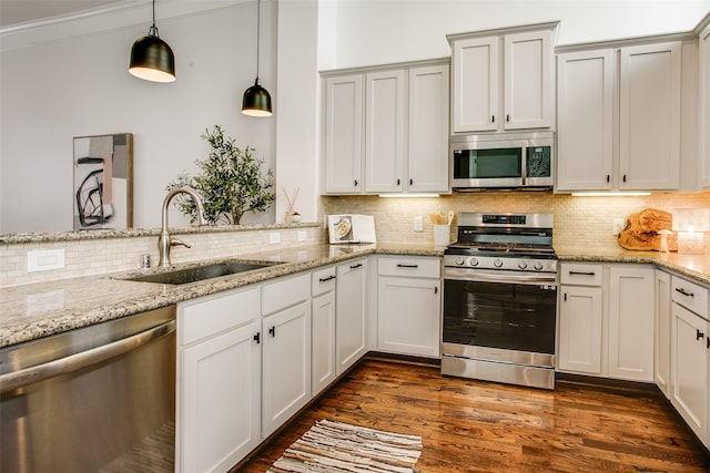 2123 Diversey St, Dallas, TX 75201 - kitchen with appliances with stainless steel finishes, a sink, decorative light fixtures, decorative backsplash, and light stone counters