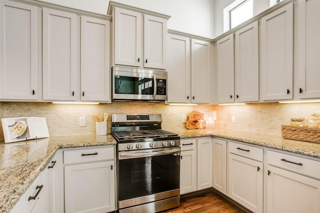 2123 Diversey St, Dallas, TX 75201 - kitchen featuring stainless steel appliances, tasteful backsplash, and light stone countertops