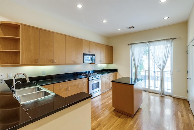 4100 Travis St Unit 19, Dallas, TX 75204 - kitchen featuring stainless steel appliances, a sink, light wood finished floors, recessed lighting, and dark countertops