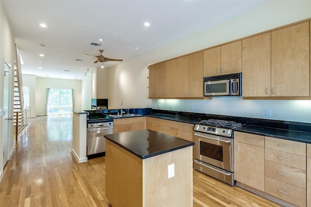 4100 Travis St Unit 19, Dallas, TX 75204 - kitchen with appliances with stainless steel finishes, light brown cabinetry, a peninsula, light wood-type flooring, and a sink