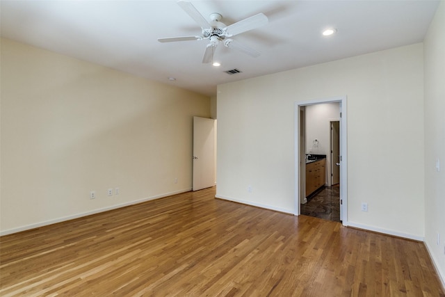 4100 Travis St Unit 19, Dallas, TX 75204 - unfurnished bedroom featuring light wood-type flooring, baseboards, recessed lighting, ensuite bath, and a ceiling fan