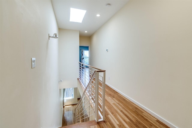 4100 Travis St Unit 19, Dallas, TX 75204 - hall featuring an upstairs landing, a skylight, light wood-style floors, baseboards, and recessed lighting