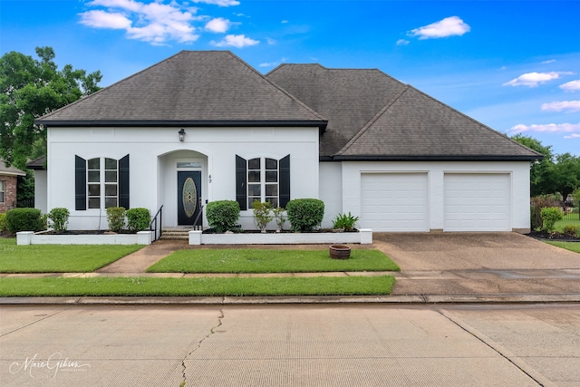 49 Turnbury Dr, Bossier City, LA 71111 - view of front facade with an attached garage, asphalt driveway, a shingled roof, and stucco siding