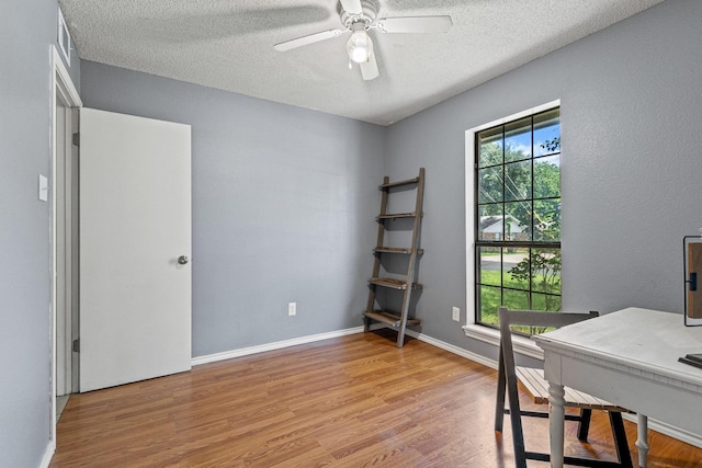 613 Locust St S, Sulphur Springs, TX 75482 - home office with wood finished floors, a textured ceiling, a ceiling fan, and baseboards