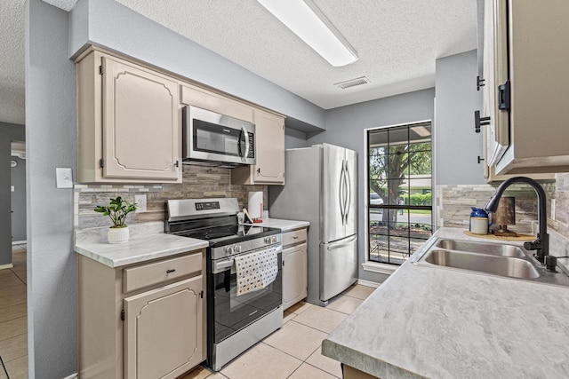 613 Locust St S, Sulphur Springs, TX 75482 - kitchen with appliances with stainless steel finishes, a sink, backsplash, a textured ceiling, and light countertops