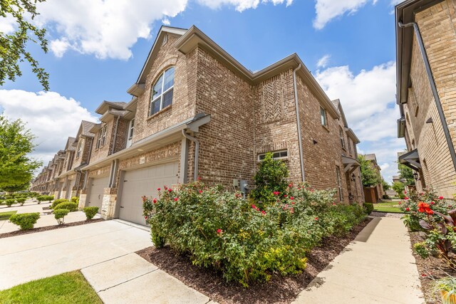 974 Mikaela Dr, Allen, TX 75013 - view of home's exterior with brick siding, a garage, and driveway