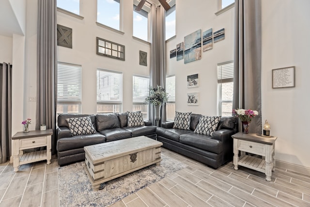 974 Mikaela Dr, Allen, TX 75013 - living area featuring plenty of natural light, wood finish floors, a high ceiling, and baseboards