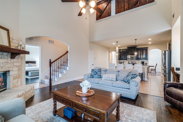 4301 Spruce Rd, Melissa, TX 75454 - living area with arched walkways, a high ceiling, a ceiling fan, stairway, and wood finished floors