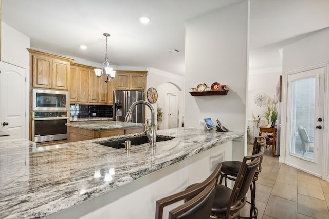 1124 Wishing Well Ct, Cedar Hill, TX 75104 - kitchen with stainless steel appliances, a sink, arched walkways, backsplash, and light stone countertops
