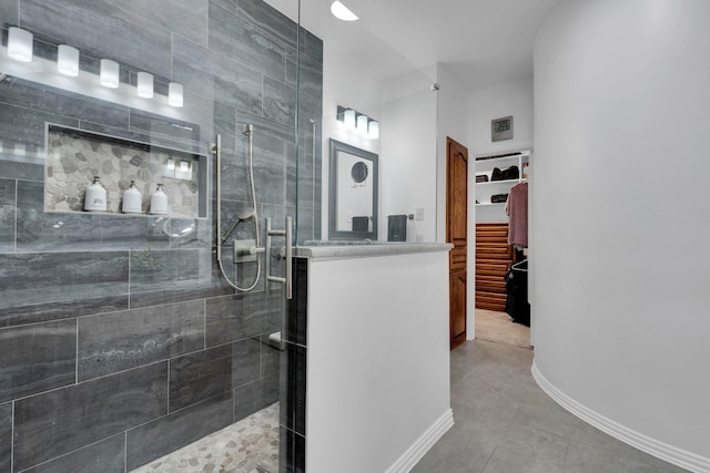 5 Remington Ct, Red Oak, TX 75154 - bathroom with a stall shower, a walk in closet, tile patterned floors, vanity, and baseboards