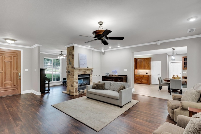 5 Remington Ct, Red Oak, TX 75154 - living area with a ceiling fan, dark wood-style flooring, crown molding, baseboards, and a stone fireplace
