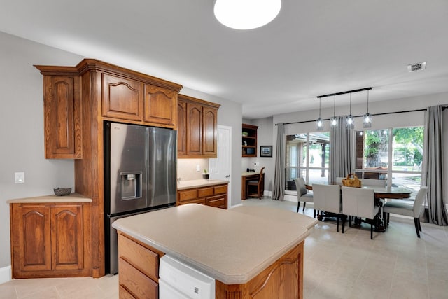 5 Remington Ct, Red Oak, TX 75154 - kitchen with stainless steel fridge, brown cabinets, pendant lighting, light countertops, and a kitchen island