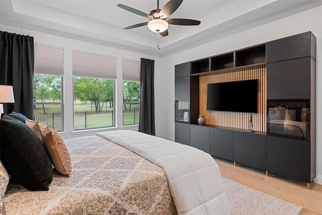 1804 Rockwood Ln, Mansfield, TX 76063 - bedroom featuring light wood-style flooring, a raised ceiling, and ceiling fan