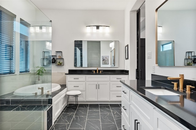 1804 Rockwood Ln, Mansfield, TX 76063 - bathroom featuring two vanities, marble look tiles, and a garden tub