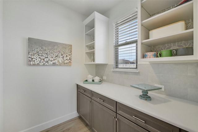 10020 Crestview Dr, Denton, TX 76207 - bar area featuring light wood-style floors, decorative backsplash, and baseboards