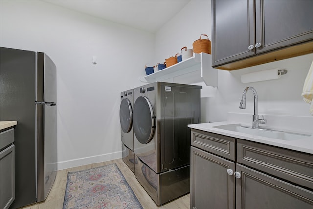 10020 Crestview Dr, Denton, TX 76207 - laundry area with separate washer and dryer, light wood finished floors, cabinet space, and baseboards