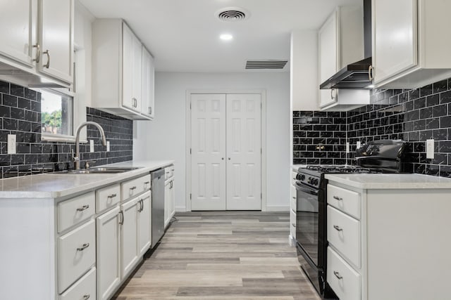 1103 Bowman St, Irving, TX 75060 - kitchen with black range with gas cooktop, a sink, stainless steel dishwasher, light countertops, and wall chimney exhaust hood