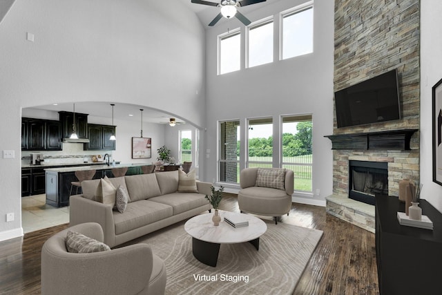1708 Stillwater Dr, Burleson, TX 76028 - living area featuring a ceiling fan, a high ceiling, a fireplace, wood finished floors, and baseboards