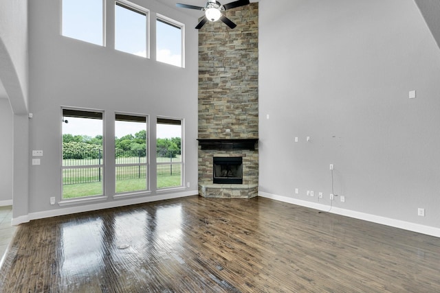1708 Stillwater Dr, Burleson, TX 76028 - unfurnished living room with ceiling fan, a towering ceiling, healthy amount of natural light, and wood finished floors