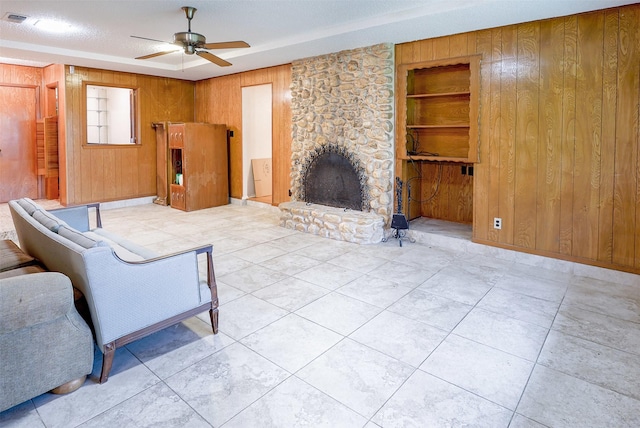 6604 Ems Ct, Fort Worth, TX 76487 - tiled living room with ceiling fan, wood walls, a fireplace, and built in features