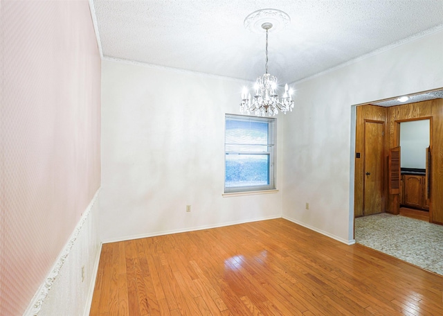 6604 Ems Ct, Fort Worth, TX 76487 - unfurnished room with a chandelier, hardwood / wood-style floors, ornamental molding, baseboards, and a textured ceiling