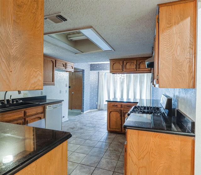 6604 Ems Ct, Fort Worth, TX 76487 - kitchen with range with gas stovetop, dishwasher, a sink, wallpapered walls, and a textured ceiling