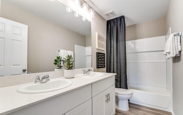 2402 Carlow Ln, Lowry Crossing, TX 75407 - full bath with double vanity, toilet, wood finished floors, and shower / bath combo with shower curtain