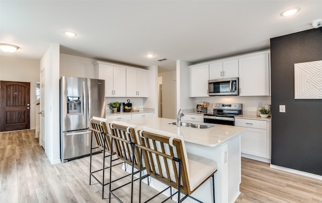 2402 Carlow Ln, Lowry Crossing, TX 75407 - kitchen featuring stainless steel appliances, a sink, light wood finished floors, light countertops, and white cabinets