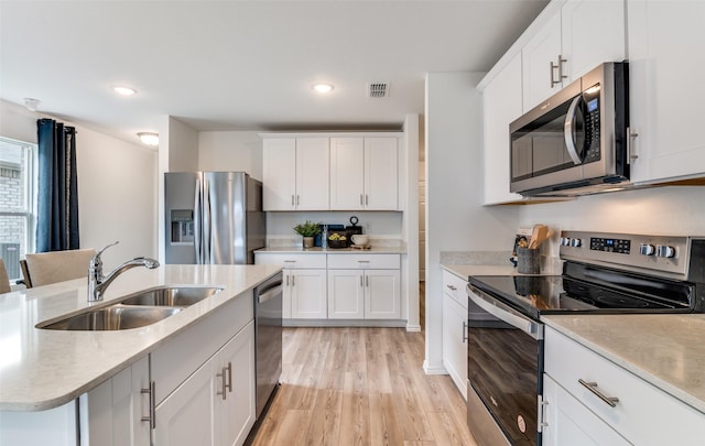 2402 Carlow Ln, Lowry Crossing, TX 75407 - kitchen with appliances with stainless steel finishes, a sink, light wood finished floors, white cabinetry, and recessed lighting
