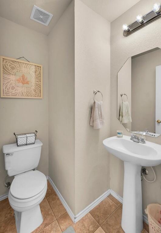 6608 Costa Dr, Waco, TX 76712 - half bathroom featuring tile patterned floors, toilet, baseboards, and a sink