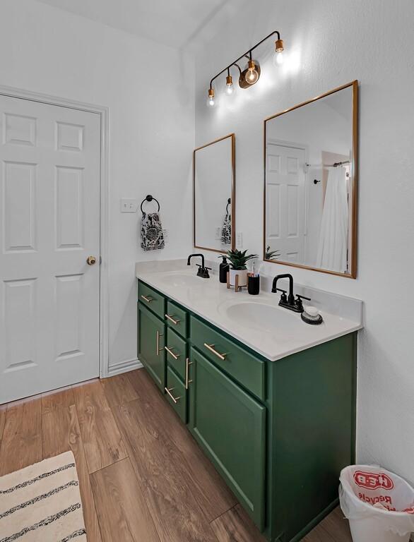 6608 Costa Dr, Waco, TX 76712 - bathroom featuring double vanity and wood finished floors